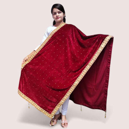 A woman posing in a maroon velvet shawl with detailed gold work, draped over her shoulders.